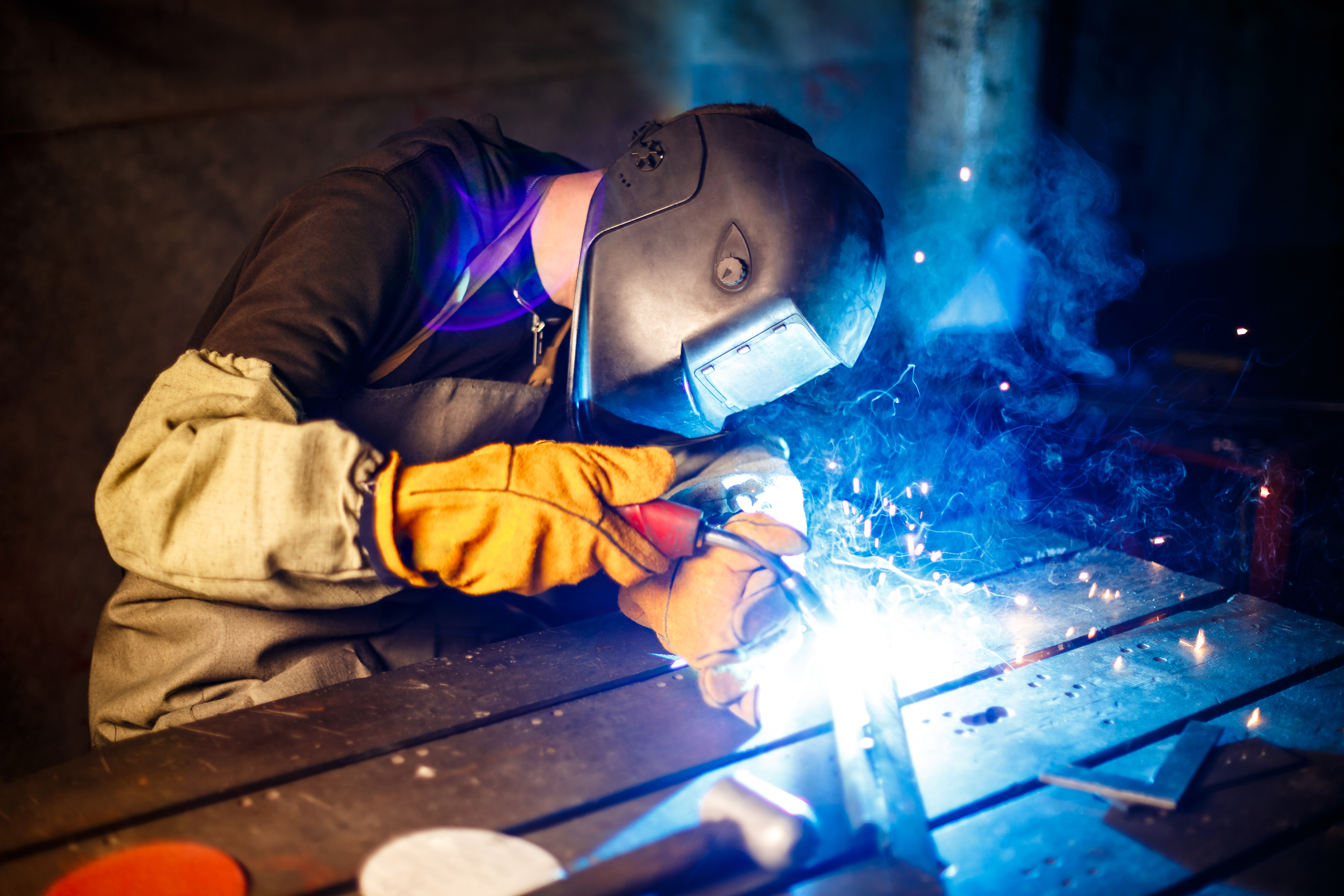 Worker cutting metal with plasma equipment. on plant